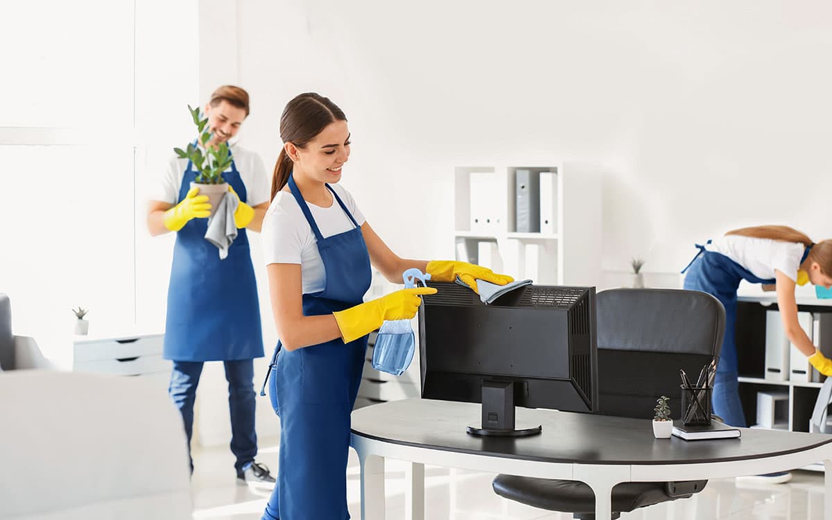 Reinigungsteam bei der Büroreinigung – Monitore, Mobiliar und Dekoration werden schonend gereinigt