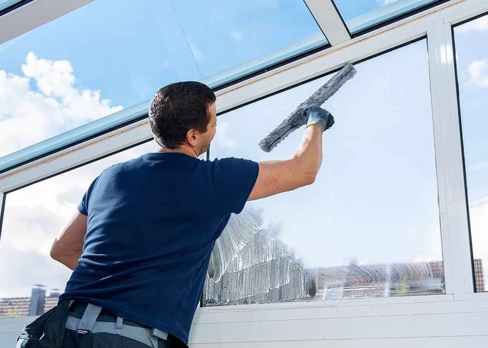 Fensterputzer reinigt Wintergarten von innen mit Einwascher – Glasreinigung in Hamburg