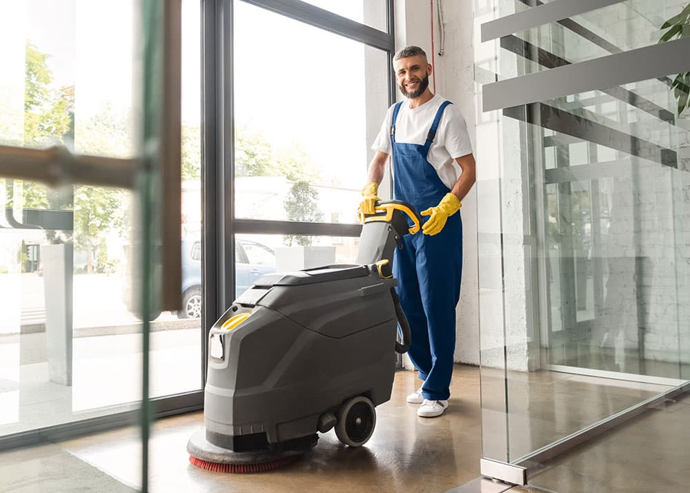 Reinigungskraft bedient Scheuersaugmaschine – Grundreinigung in Hamburg