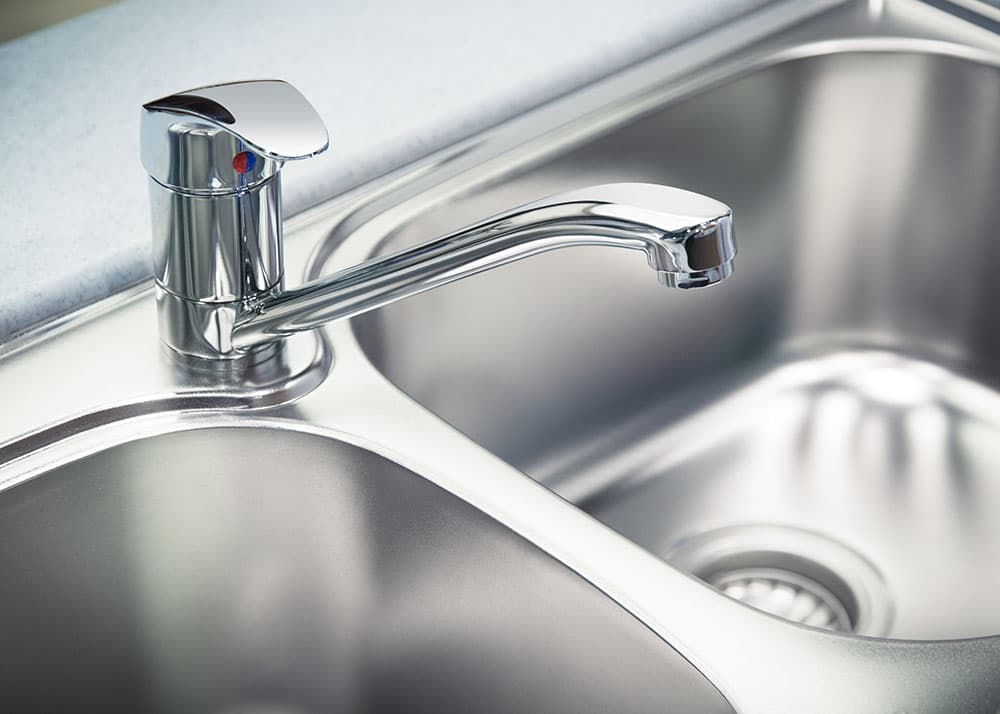 Blitzsaubere Edelstahlarmatur und Spülbecken nach der Grundreinigung – hygienische Küchenreinigung für Gewerbeobjekte