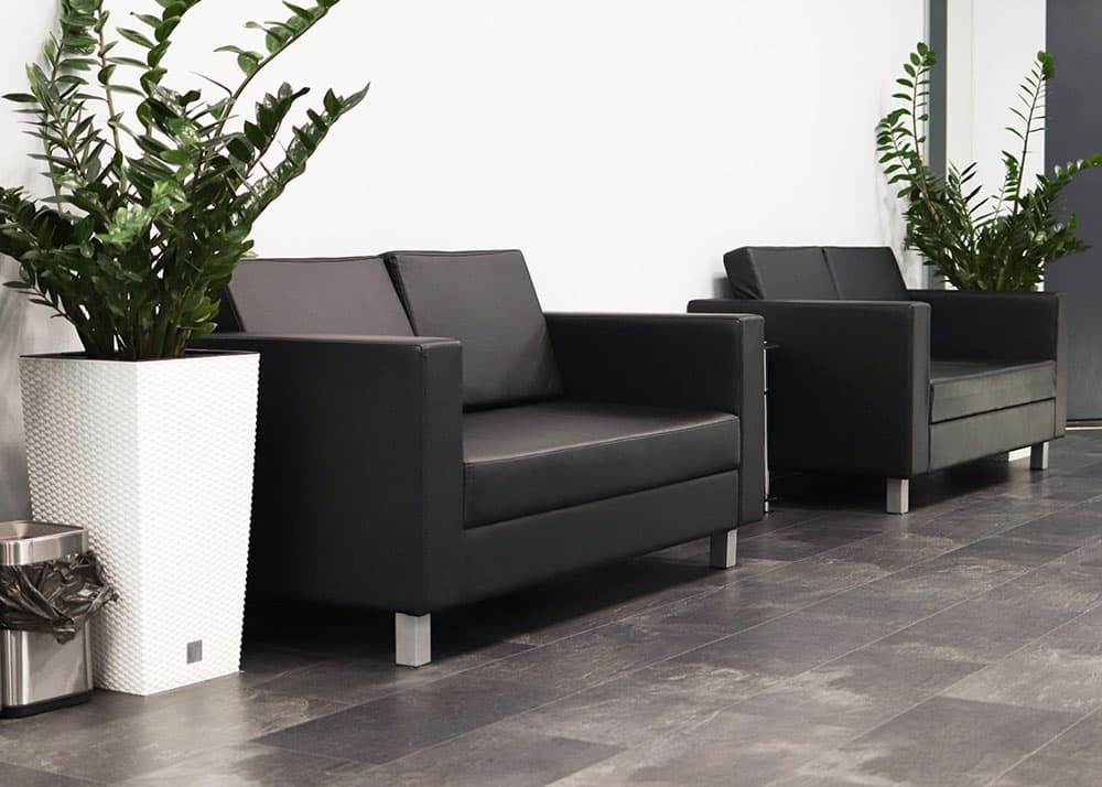 Professionelle Reinigung von Wartebereichen und Empfangsräumen in Hamburg: Gepflegte Sofas und Pflanzen für einen einladenden ersten Eindruck durch Oxonio